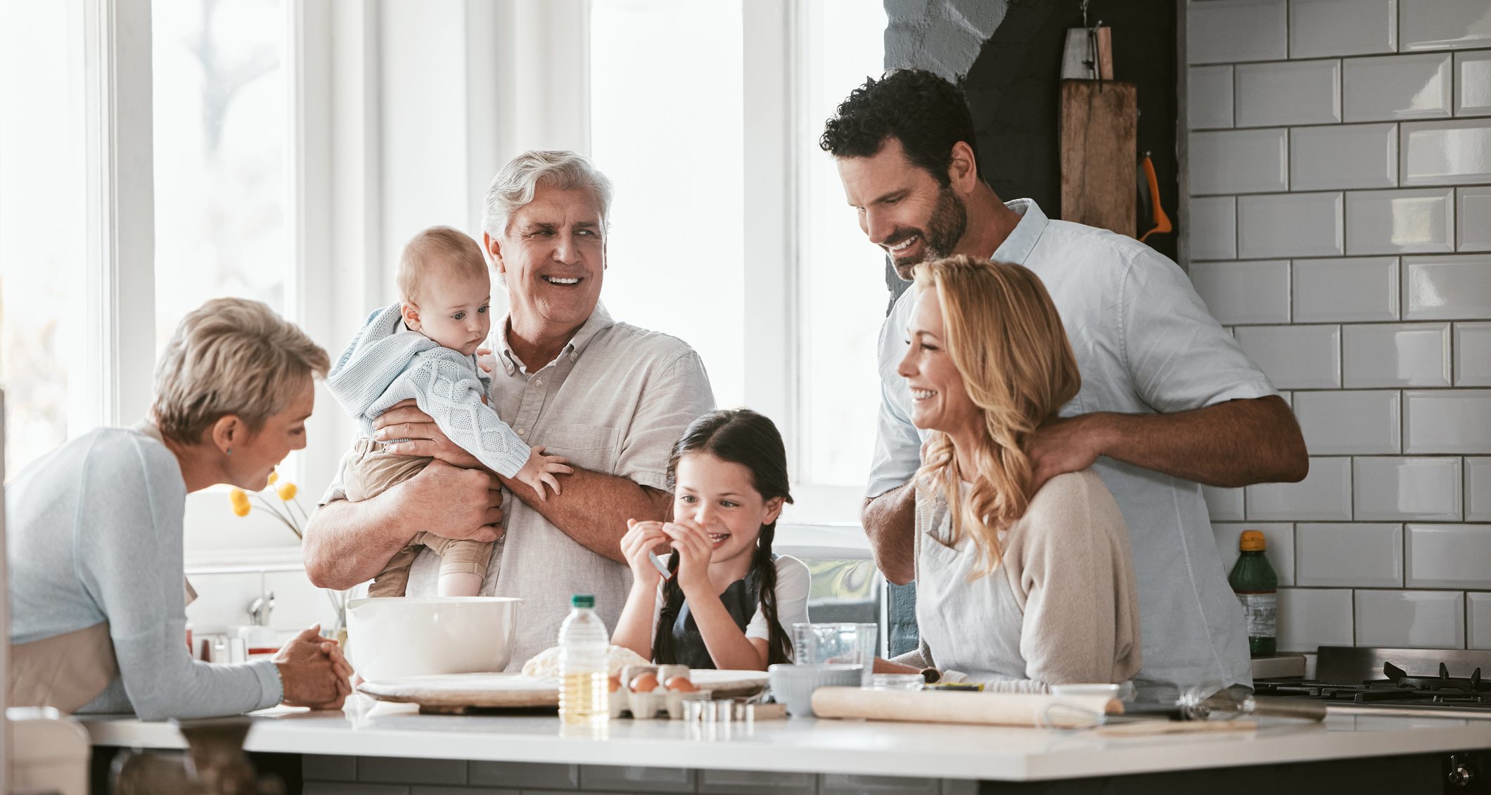 Multi-Generational family, love and cooking in home kitchen, bonding or having fun. Support, care and grandparents, father and mother, baby and girl baking, learning and talking while enjoying quality time together